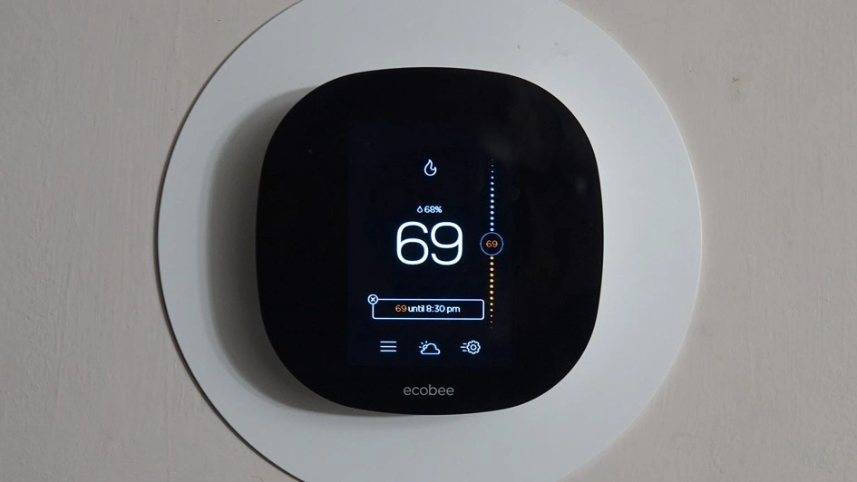 Smart thermostat displaying temperature and settings.