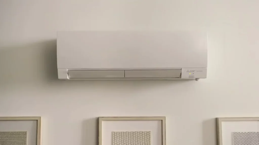 A white modern Mitsubishi ductless mini-split indoor unit mounted on a wall.